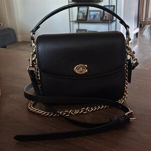COACH Cassie crossbody in polished black pebbled leather.
